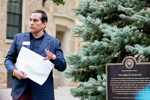 Aaron Bird Bear leading First Nations walking tour and holding a piece of paper.