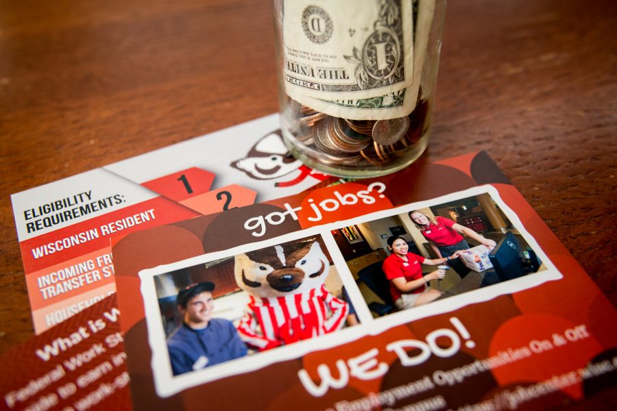 Flyers for UW-Madison employment and coin jar on a table