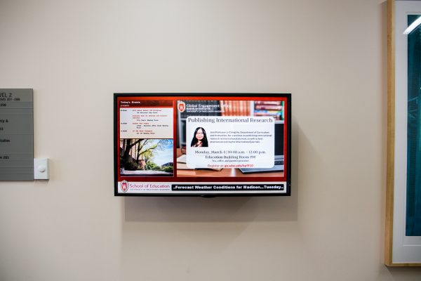Current news information on digital screen on wall.