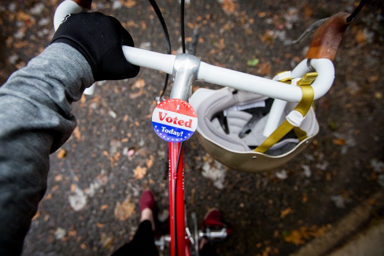 First person point of view holding bike with an "I Voted Today" sticker on handle bars.