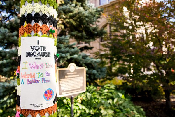 Crochet sleeve for lamp pole with paper attached stating, " I vote because..."