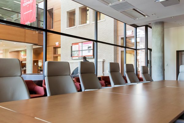 Conference room with wide windows and brown leather chairs.